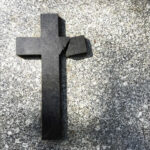 Broken black cross on a gray surface