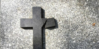 Broken black cross on a gray surface