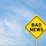 Full-Blown Crisis: America on the Brink? Yellow sign reads bad news in sky