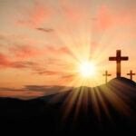 Three crosses on a hill, sunrise background.