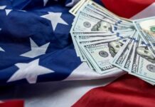 Stack of hundred dollar bills on an American flag