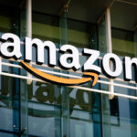 Amazon’s Bold Move Exposes Economic Truth Amazon logo on a glass office building