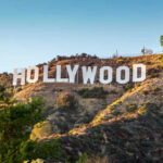 Cinema Icon DIES — Golden Era Closes Hollywood sign on a sunny hillside.