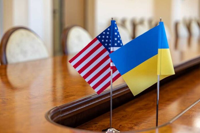 shutterstock_2372540703.jpg American and Ukrainian flags displayed on a conference table