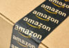 Amazon’s AI Gamble — Engineers Axed By The Thousands Close-up of an Amazon-branded shipping box tape on a cardboard box