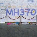 A large wall covered in messages and prayers for MH370