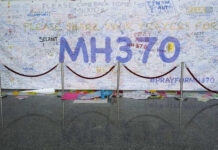 MH370 BREAKTHROUGH? The Hunt Begins Again A large wall covered in messages and prayers for MH370