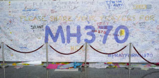 A large wall covered in messages and prayers for MH370