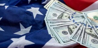Stack of hundred dollar bills on an American flag