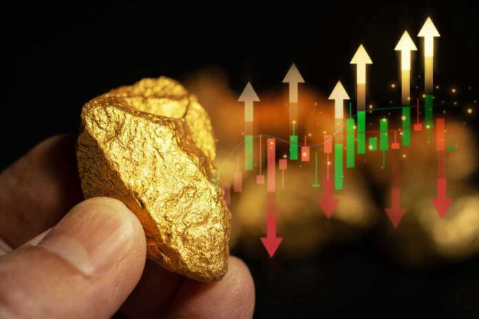 Hand holding gold nugget with financial market chart.