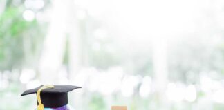 Globe with a graduation cap next to stacks of coins and wooden blocks displaying the year 2026