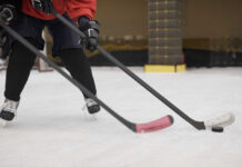 Close-up of hockey players on ice with sticks in motion