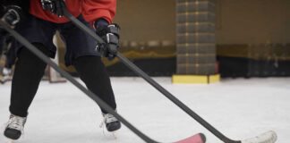 Close-up of hockey players on ice with sticks in motion