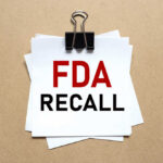 Dangerous Contamination Sparks FDA Dog Treat Recall A notice labeled 'FDA RECALL' clipped to white papers on a brown background