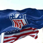 NFL flag waving in front of American flag.
