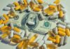 A one hundred dollar bill surrounded by various capsules and pills