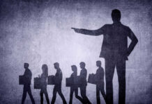 Shadows of laid-off workers walking, large figure pointing.