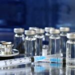 FDA Pulls Sudden U-Turn On mRNA Vaccine Medical vials and syringes arranged on a reflective surface