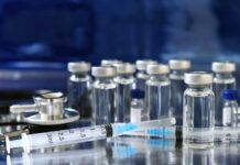 FDA Pulls Sudden U-Turn On mRNA Vaccine Medical vials and syringes arranged on a reflective surface