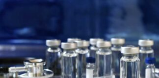Medical vials and syringes arranged on a reflective surface