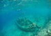 Ghost Ship Found Upright, Shockingly Intact An underwater scene featuring a shipwreck surrounded by fish and coral