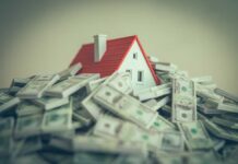 A small model house surrounded by stacks of money