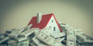 A small model house surrounded by stacks of money