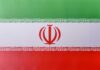 The flag of Iran featuring green, white, and red horizontal stripes with a central emblem