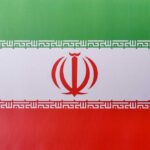 The flag of Iran featuring green, white, and red horizontal stripes with a central emblem