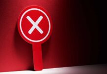 Red sign with a white 'X' symbol against a dark background