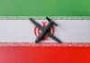 Two-Carrier Armada Converging On Iran A model airplane placed on the Iranian flag