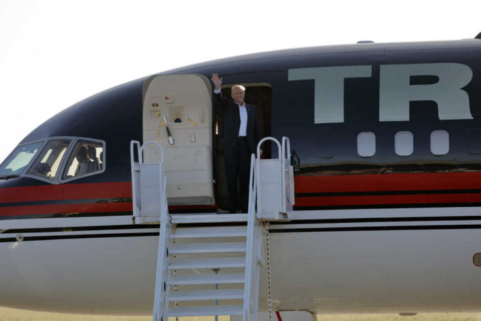 shutterstock_437477398.jpg Person waving from the doorway of an airplane