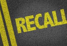 Yellow 'RECALL' text on a dark asphalt surface