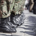 Trump Threatens National Guard Airports Row of soldiers in black boots and camouflage pants standing in formation