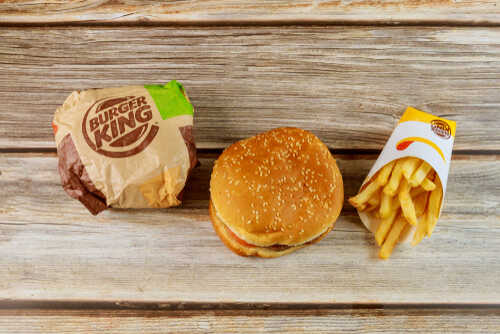 Burger King hamburger and fries on a wooden surface