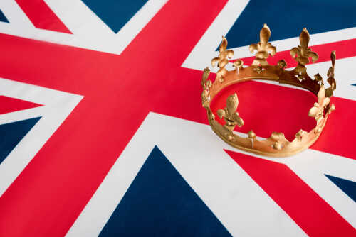 shutterstock_1635200170.jpg A golden crown resting on the Union Jack flag