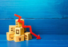 Stack of cardboard boxes with a red downward arrow indicating decline