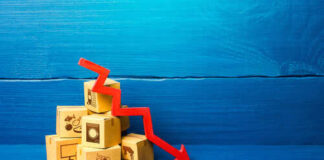 Stack of cardboard boxes with a red downward arrow indicating decline