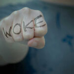 Trump Crushes Woke Prison Surgeries Fist with Woke written on fingers.