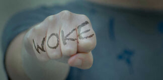 Fist with Woke written on fingers.
