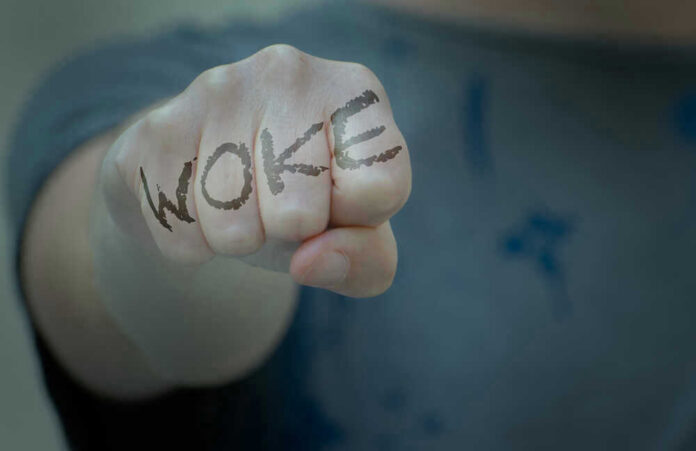 Fist with Woke written on fingers.