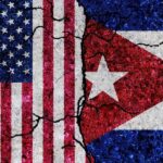 Cracked flags of the United States and Cuba on a textured surface