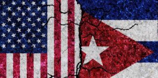 Cracked flags of the United States and Cuba on a textured surface