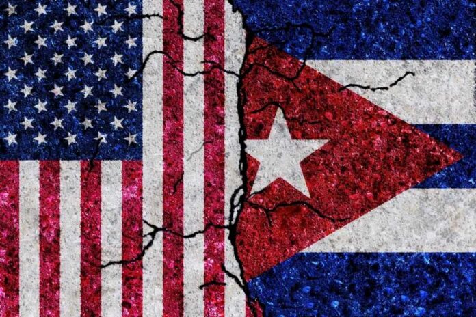 Cracked flags of the United States and Cuba on a textured surface