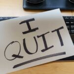 A resignation letter reading 'I QUIT' placed on a keyboard