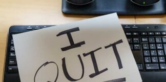 A resignation letter reading 'I QUIT' placed on a keyboard
