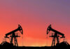 Oil pumps silhouetted against colorful sky background