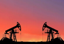 Oil Crisis Looms? Oil pumps silhouetted against colorful sky background