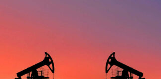 Oil pumps silhouetted against colorful sky background