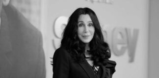 Cher with dark hair smiling.
